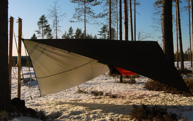 Zdjęcie prezentuje Thermo tarp 4x3 rozwieszony nad hamakiem. Idealne schronienie.